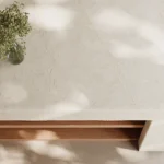 Caesarstone ICON 8251 Taj Whisper Kitchen with minimalist marble table with a small glass vase holding delicate greenery.